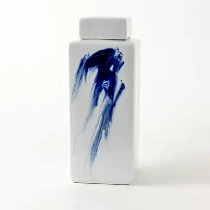 Tall white ceramic jar with blue brushstroke design displayed on plain background for modern artistic décor.