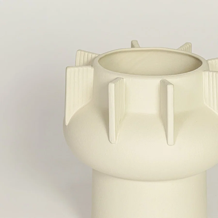 Close view of beige textured ceramic vase with ribbed sculptural details highlighting matte finish for table or shelf placement.