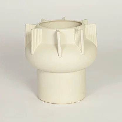 Modern beige ceramic statement vase with rounded form and vertical sculptural accents for coffee table console or shelf styling.