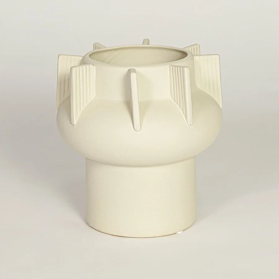 Modern beige ceramic statement vase with rounded form and vertical sculptural accents for coffee table console or shelf styling.