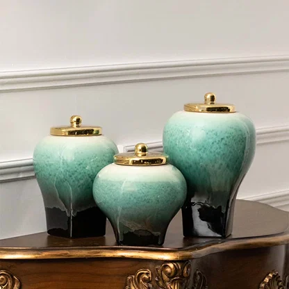 Set of teal ceramic decorative vases with gradient glaze and gold lids arranged together on white background for decor display.