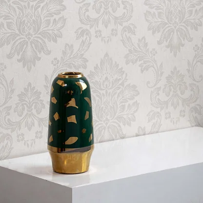 Glossy emerald green ceramic vase accented with gold terrazzo flecks and a polished metallic gold base for luxury style.