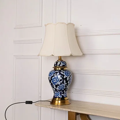 Unlit floral ceramic lamp with gold base and cream shade displays artistic floral detailing perfect as an elegant decor centerpiece.