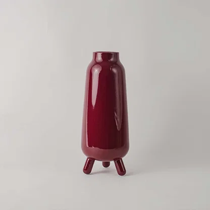 Decorative ceramic vase with deep red glaze sculpted body and minimal design ideal for console table shelf decor.