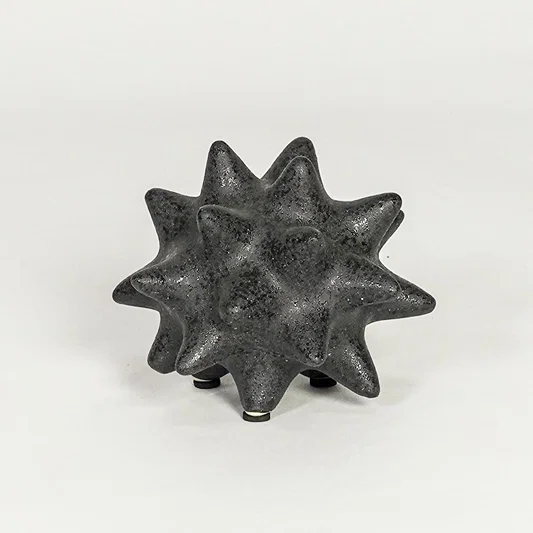 Modern black ceramic statement decor accent with starburst inspired sculpted shape for contemporary interiors.