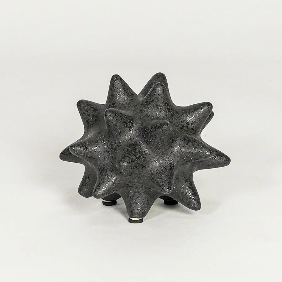 Modern black ceramic statement decor accent with starburst inspired sculpted shape for contemporary interiors.
