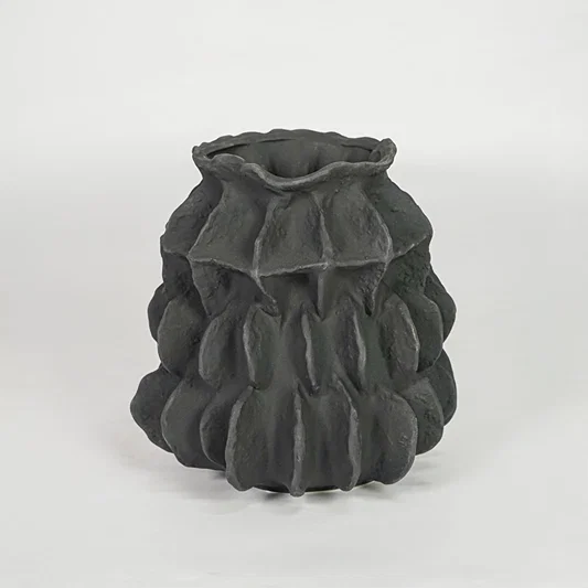 Closeup of dark grey ceramic vase with detailed sculpted texture for luxury tabletop and shelf decor home styling ideas.