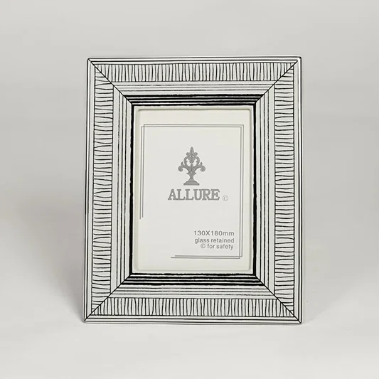 Silver metal photo frame with detailed patterned border isolated on clean white background for elegant tabletop display.