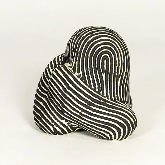 Abstract striped ceramic decor piece on white background modern artistic tabletop accent for living room office or entryway decor.