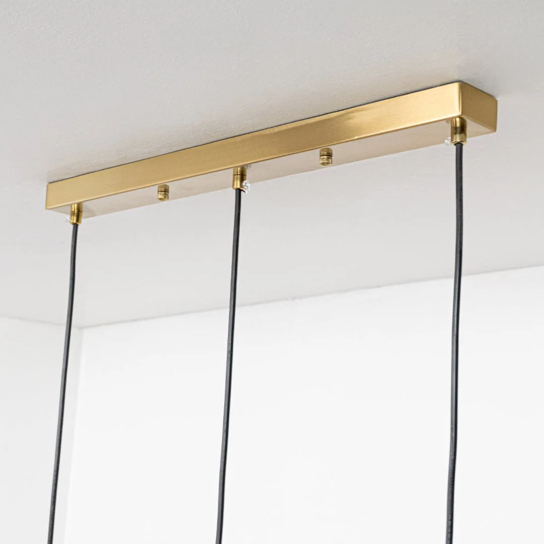 Gold metal linear ceiling canopy with suspended cords showcasing sleek modern craftsmanship and finish.