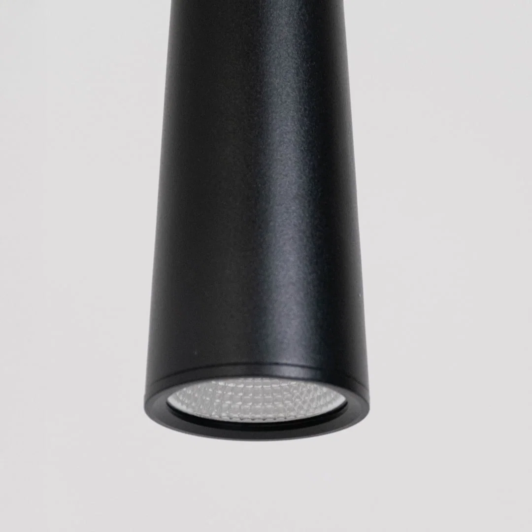 Closeup of black metal cone pendant light showcasing smooth finish and contemporary craftsmanship.