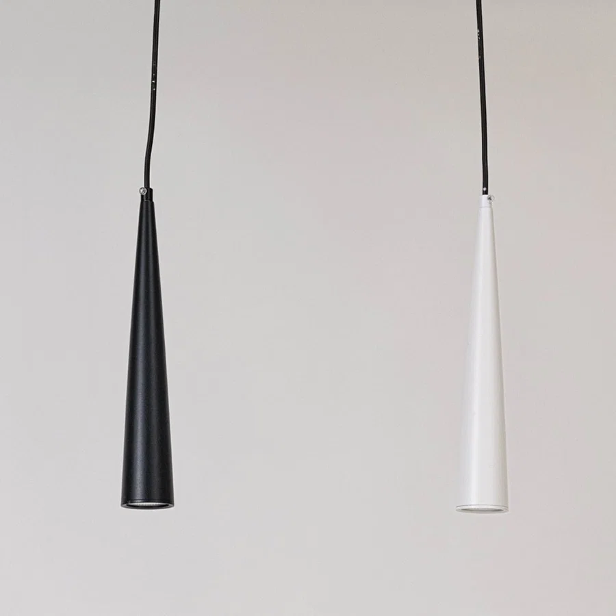 Pair of black and white metal cone pendant lights designed for elegant dining room interiors.