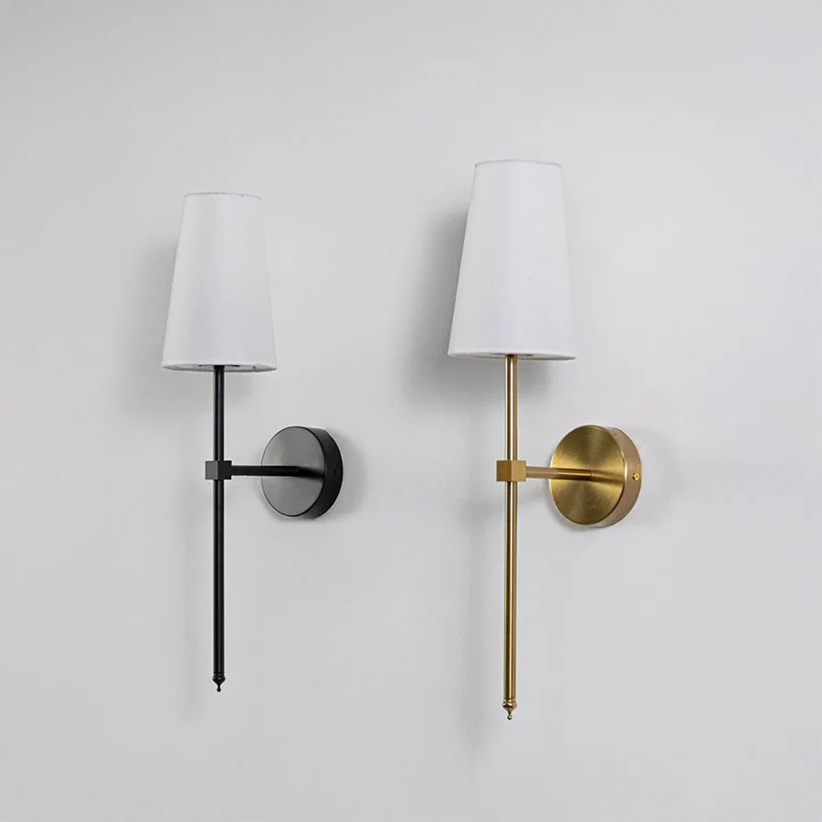 Collection of stylish white drum shade wall sconces with black metal frames displayed off together on clean white backdrop.