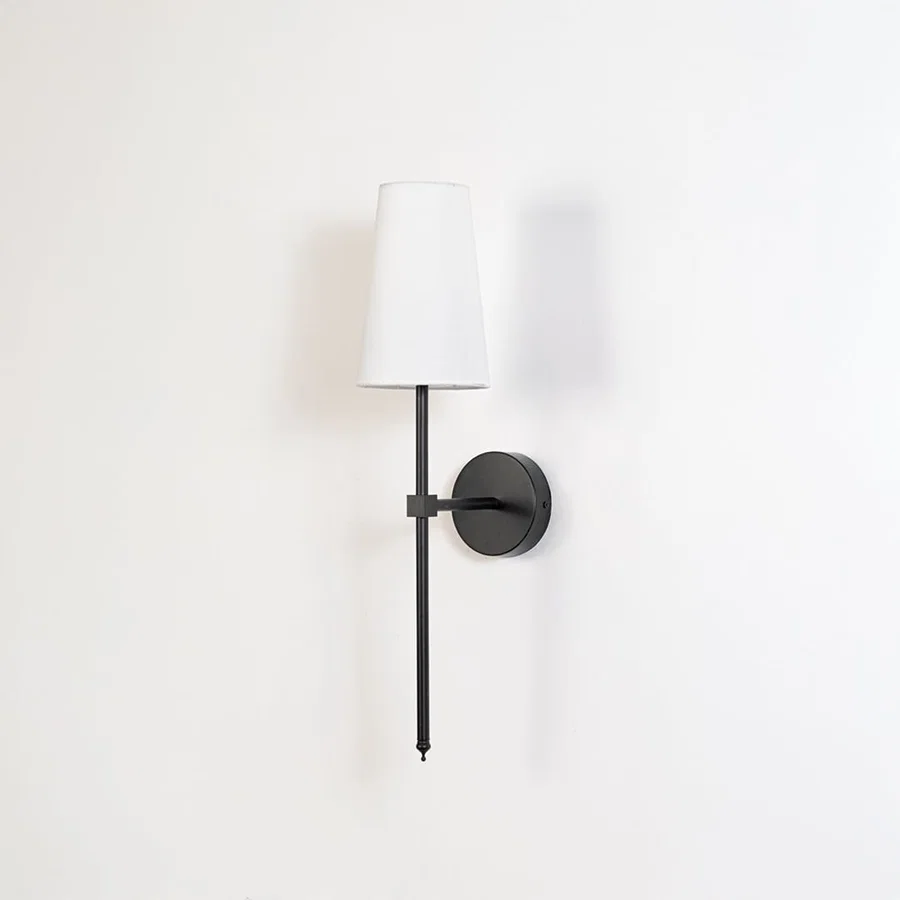 Contemporary white drum shade wall light fixture with tall black metal rod turned off on minimalist white background display.