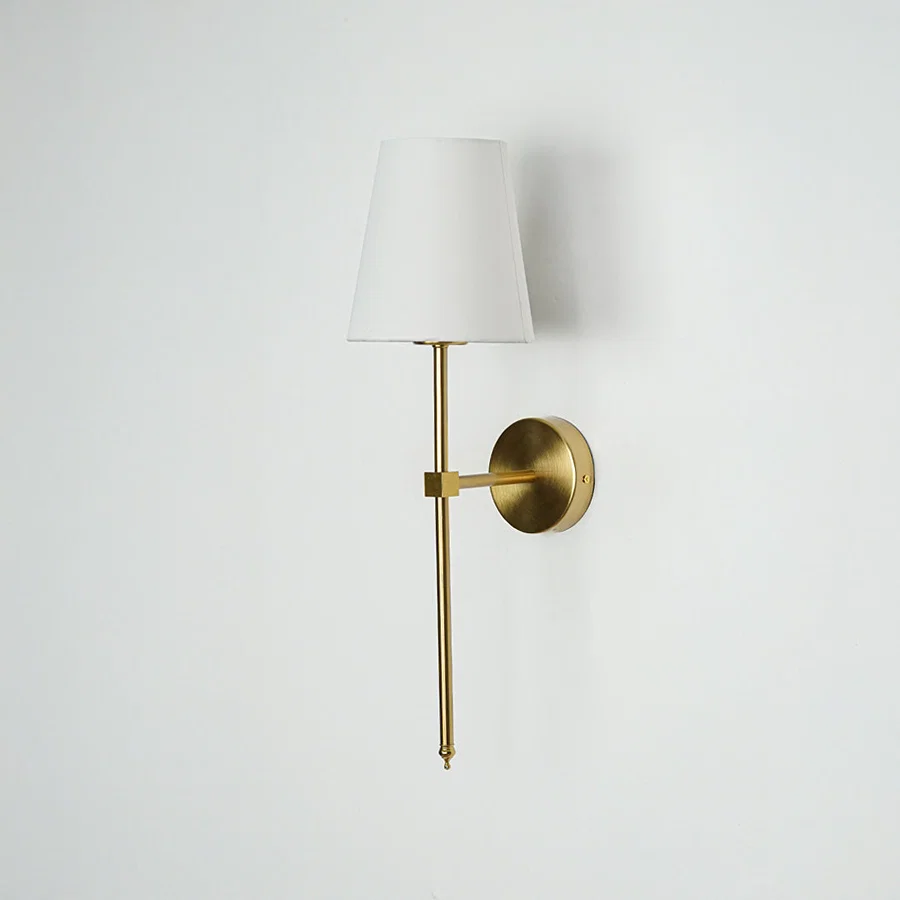 Minimal wall light in gold metal finish with fabric shade for bedroom or living room decor lighting white background.