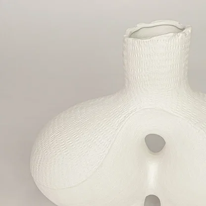 Closeup of white ceramic vase with sculpted textured finish for elegant tabletop and shelf decor styling ideas.