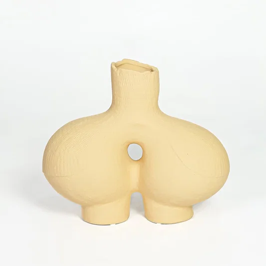 Contemporary beige ceramic decorative vase with unique hollow center for minimalist home decor styling.