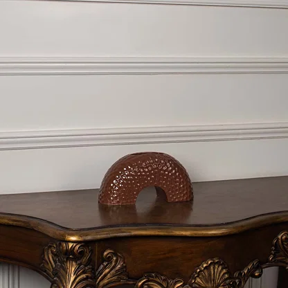 Brown arched ceramic vase displayed on a clean white background  showing its textured surface and curved modern silhouette clearly.