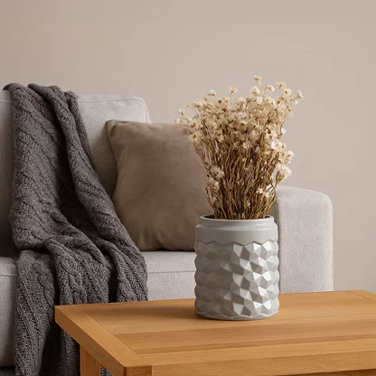 Grey textured ceramic vase styled in a soft minimal setup adding a modern decorative accent to shelves and tabletops with a clean look.
