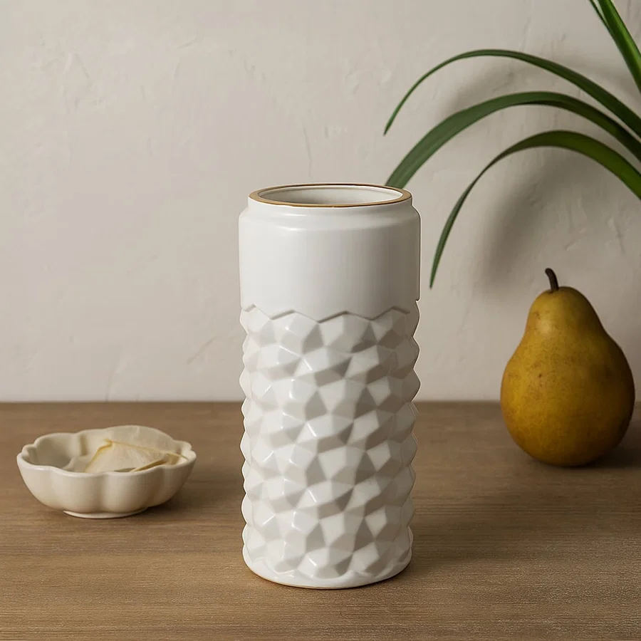 White textured ceramic vase with gold rim styled on a soft minimal background creating a modern decorative accent for shelves and consoles.