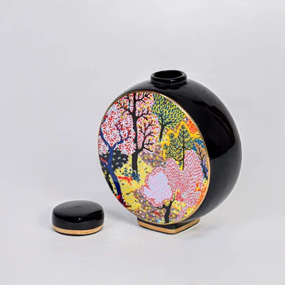 Round ceramic decorative jar with matching lid and colorful tree artwork for elegant tabletop home decor displays.
