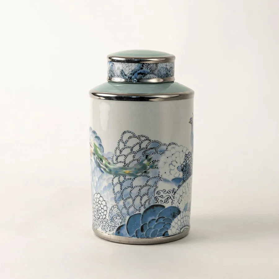 White ceramic decorative jar with blue wave pattern and silver lid for sophisticated tabletop styling and home decor.