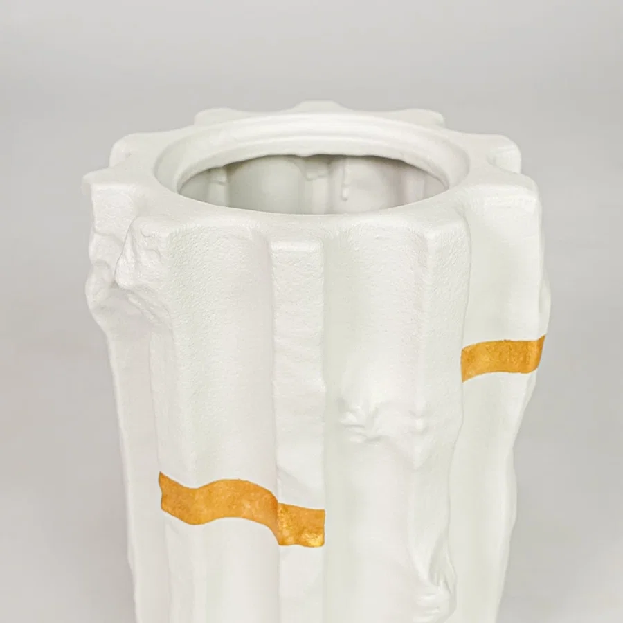 White ceramic decorative vase closeup with gold accent modern flower vase for shelf console living room decor styling.
