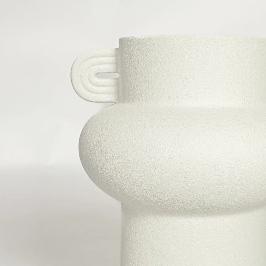 Close view of white textured ceramic decorative vase with sculptural handles showing matte finish suitable for shelf table or console decor.