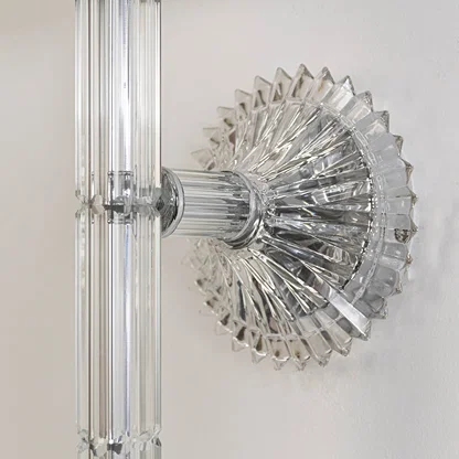 Closeup of wall light with chrome base fabric shade and crystal drop accent for modern home decoration.