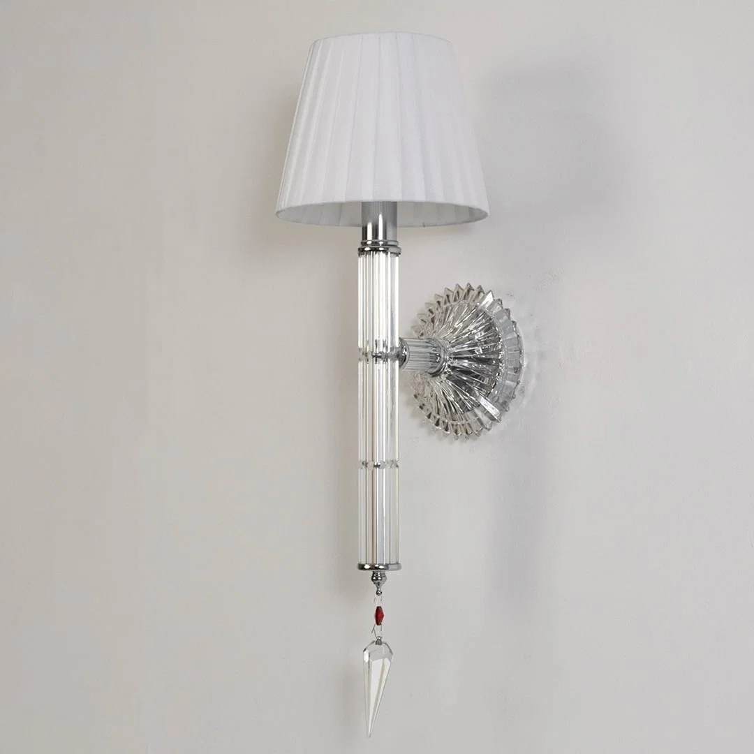 Wall light with chrome base fabric shade and crystal accents turned off on white background for decor.