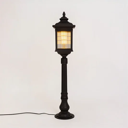 Vintage black outdoor bollard light with warm glowing panels for luxury exterior decor styling use.