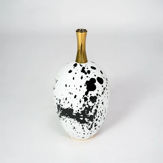White ceramic vase with black abstract pattern for modern shelf placement and stylish indoor decor styling accent piece.