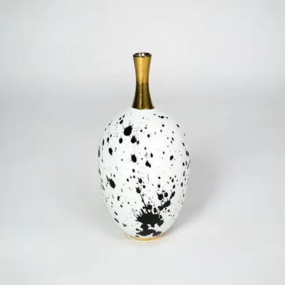 White ceramic vase with gold neck for stylish table placement and modern indoor home decor styling accent piece.