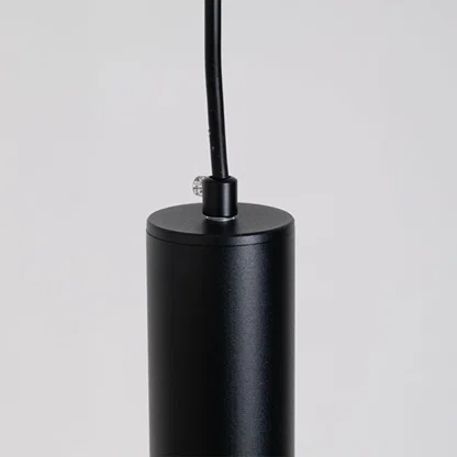 Closeup of black metal cylindrical pendant light showcasing sleek finish and premium craftsmanship.