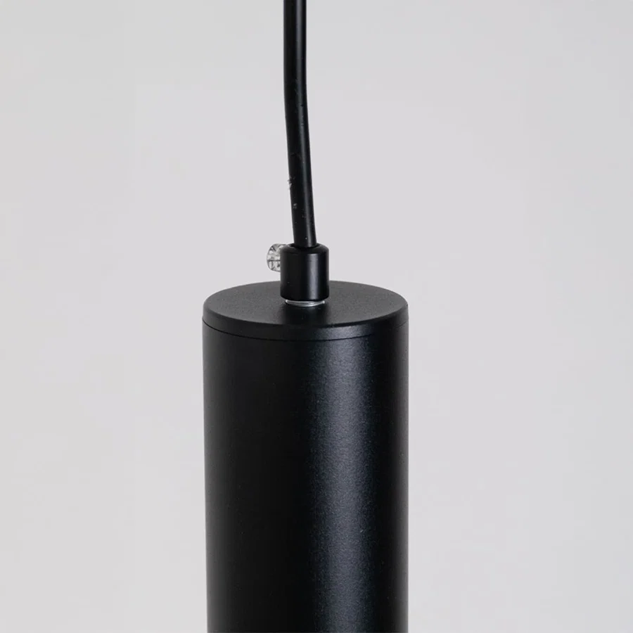 Closeup of black metal cylindrical pendant light showcasing sleek finish and premium craftsmanship.