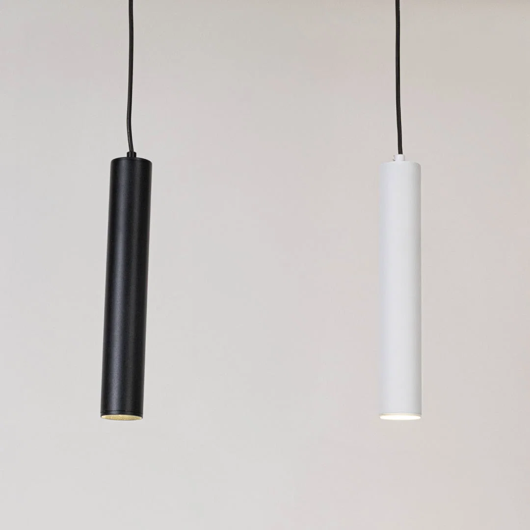 Black and white metal cylindrical pendant lights showcasing sleek minimalist designs for modern interiors.