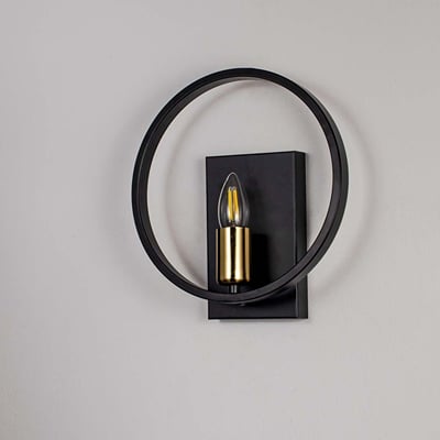 Modern wall light with matte black circular frame and gold bulb holder shown off on white background for stylish interiors.