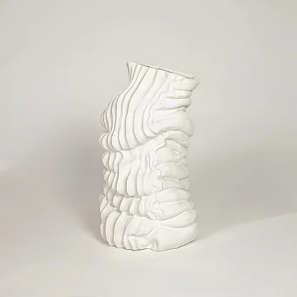 Modern white ceramic sculpted wave design decorative vase ideal for dried floral arrangement in living room corner and home decor styling.