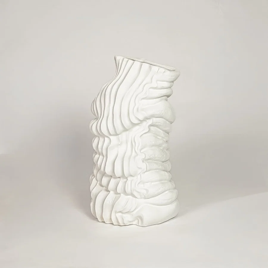 Modern white ceramic sculpted wave design decorative vase ideal for dried floral arrangement in living room corner and home decor styling.
