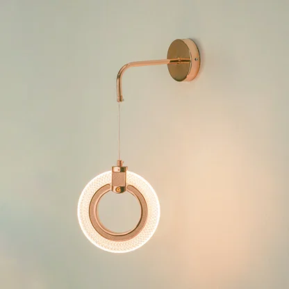 Premium rose gold led ring wall sconce lighting fixture glowing on wall for contemporary living room home decor styling.