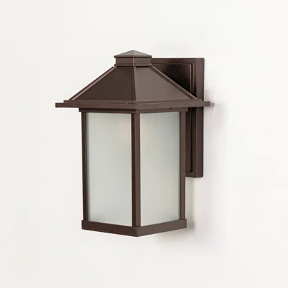 Brown metal wall mounted outdoor lantern switched off on white background emphasizing clean structure and frosted glass panels.