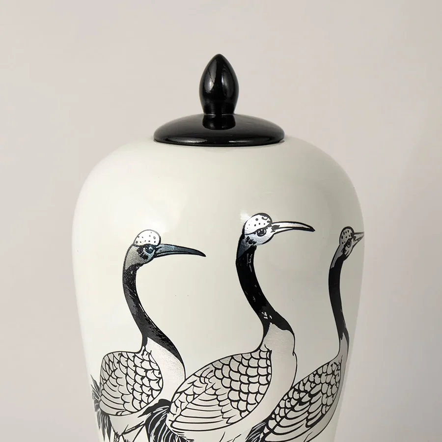 White ceramic decorative jar with black crane artwork and black lid for elegant shelf styling and modern home decor.