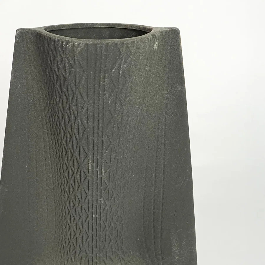 Close up view black textured ceramic vase showing carved surface matte finish decorative ceramic accent for modern home styling.