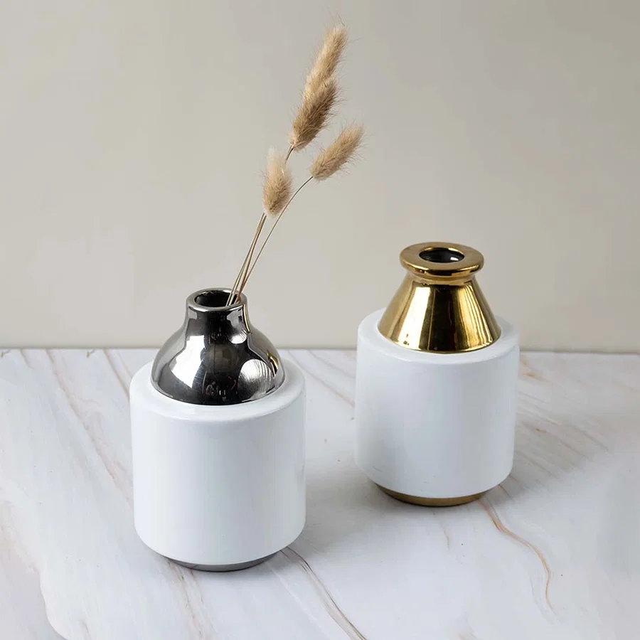 White and gold ceramic vase shown as part of a grouped decor setup adding a touch of luxury to modern home arrangements.