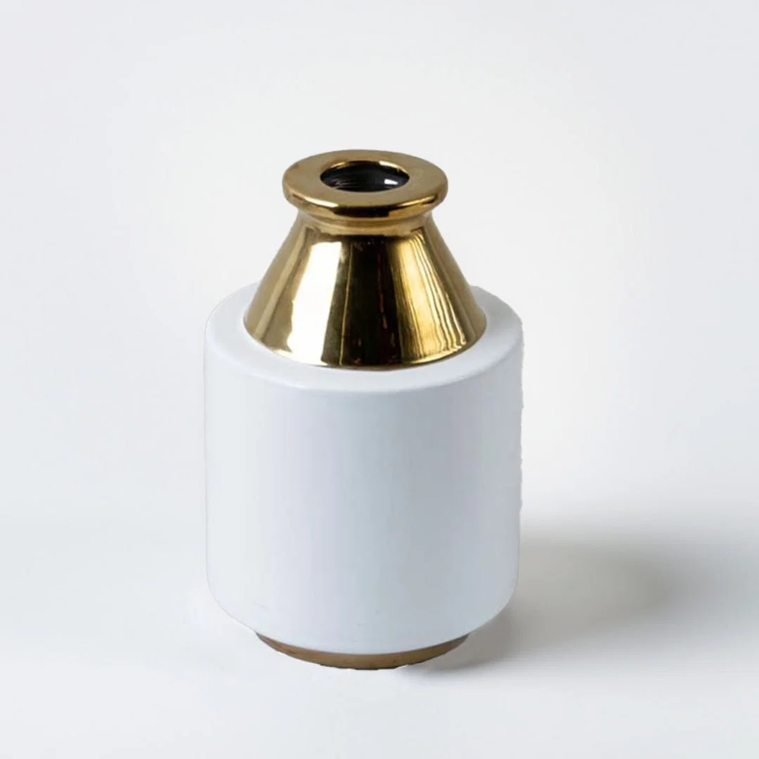 Minimalist white ceramic cylindrical pillar vase featuring a metallic polished gold conical neck on a white background.