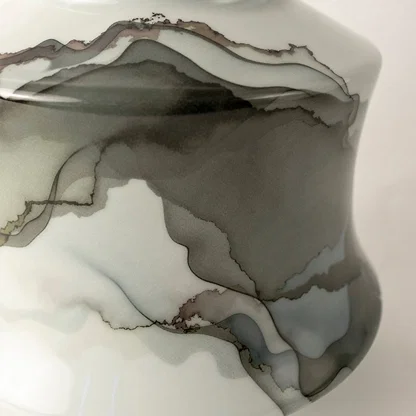 White ceramic jar with soft gray abstract swirl design displayed on plain background for elegant décor.