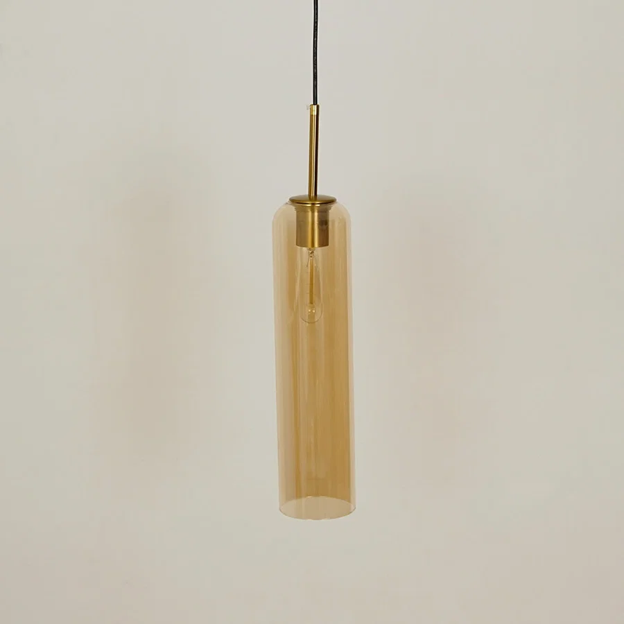 Amber glass pendant light with brass accents adding modern elegance to kitchen ceiling placement.