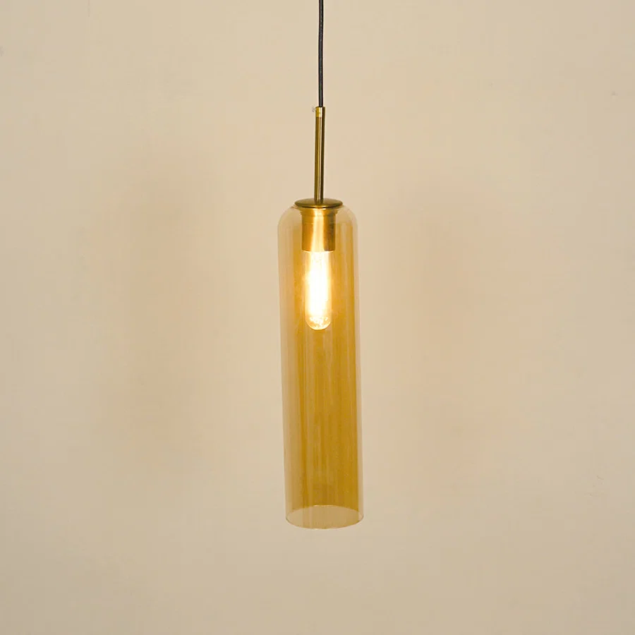 Amber glass pendant light illuminated with warm glow for stylish dining room ceiling decor.