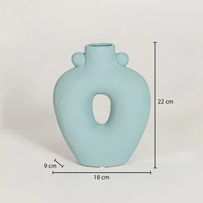 Light blue ceramic sculpted loop vase measuring 22 cm height 18 cm width and 9 cm depth perfect for contemporary home styling.