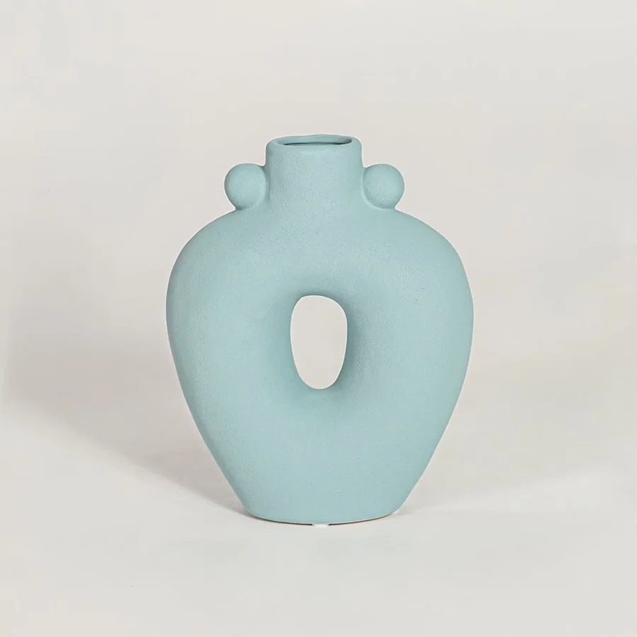 Contemporary light blue ceramic flower vase with abstract cutout shape perfect for entryway table living room decor display.